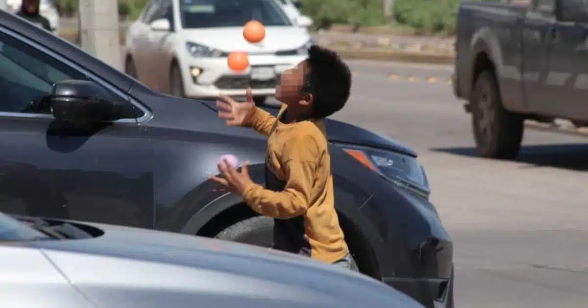 Niño trabajando en semáforo