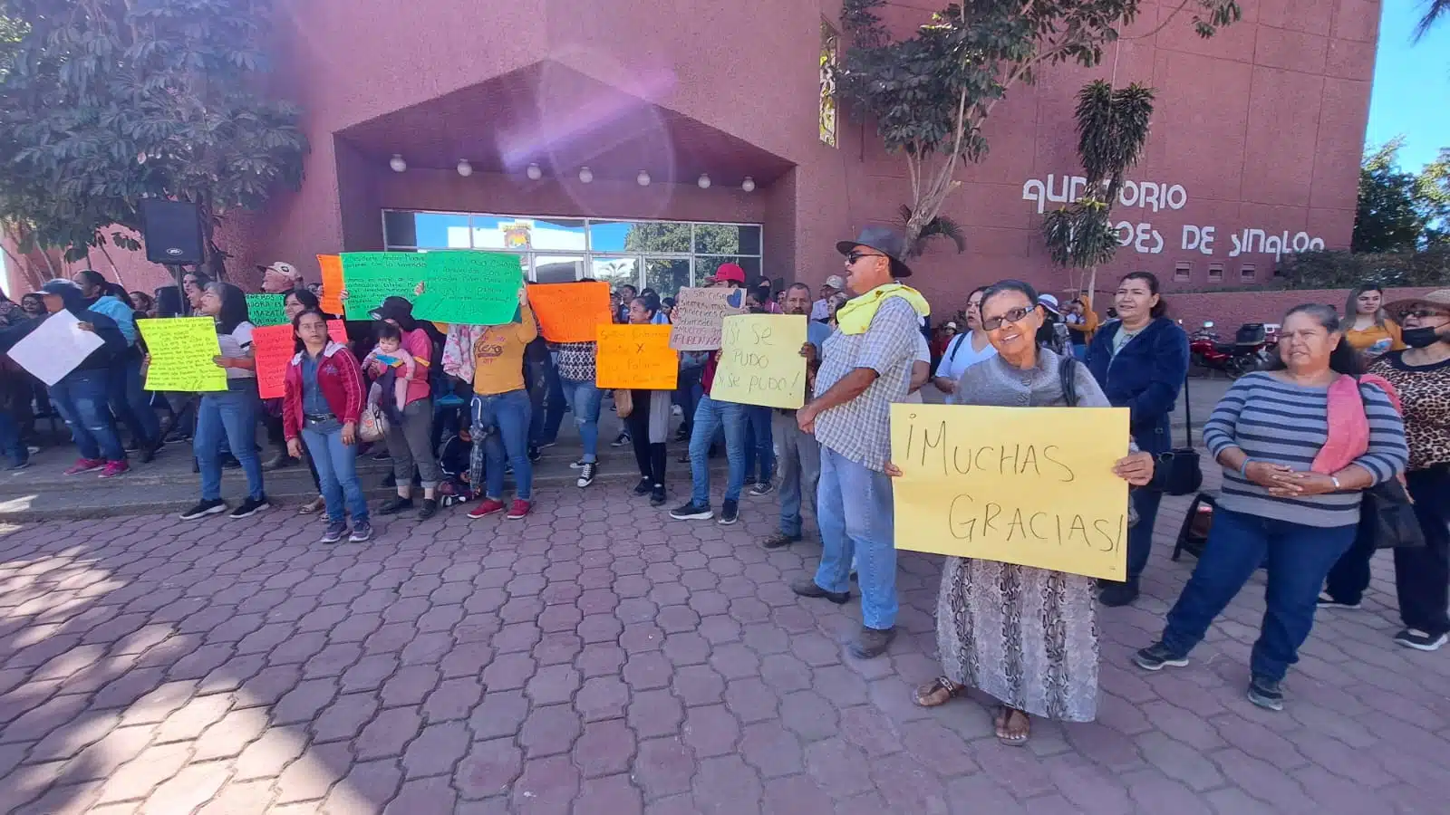 Integrantes de la Coordinadora Estatal para la Defensa del Derecho Humano a la Vivienda y Reservas Territoriales afuera de las instalaciones del Palacio Municipal en Guasave con pancartas de agradecimiento