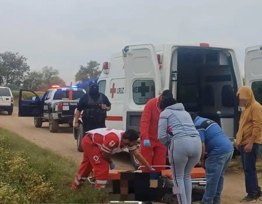 Paramédicos de Cruz Roja auxiliando al joven lesionado. Hay testigos y autoridades presentes