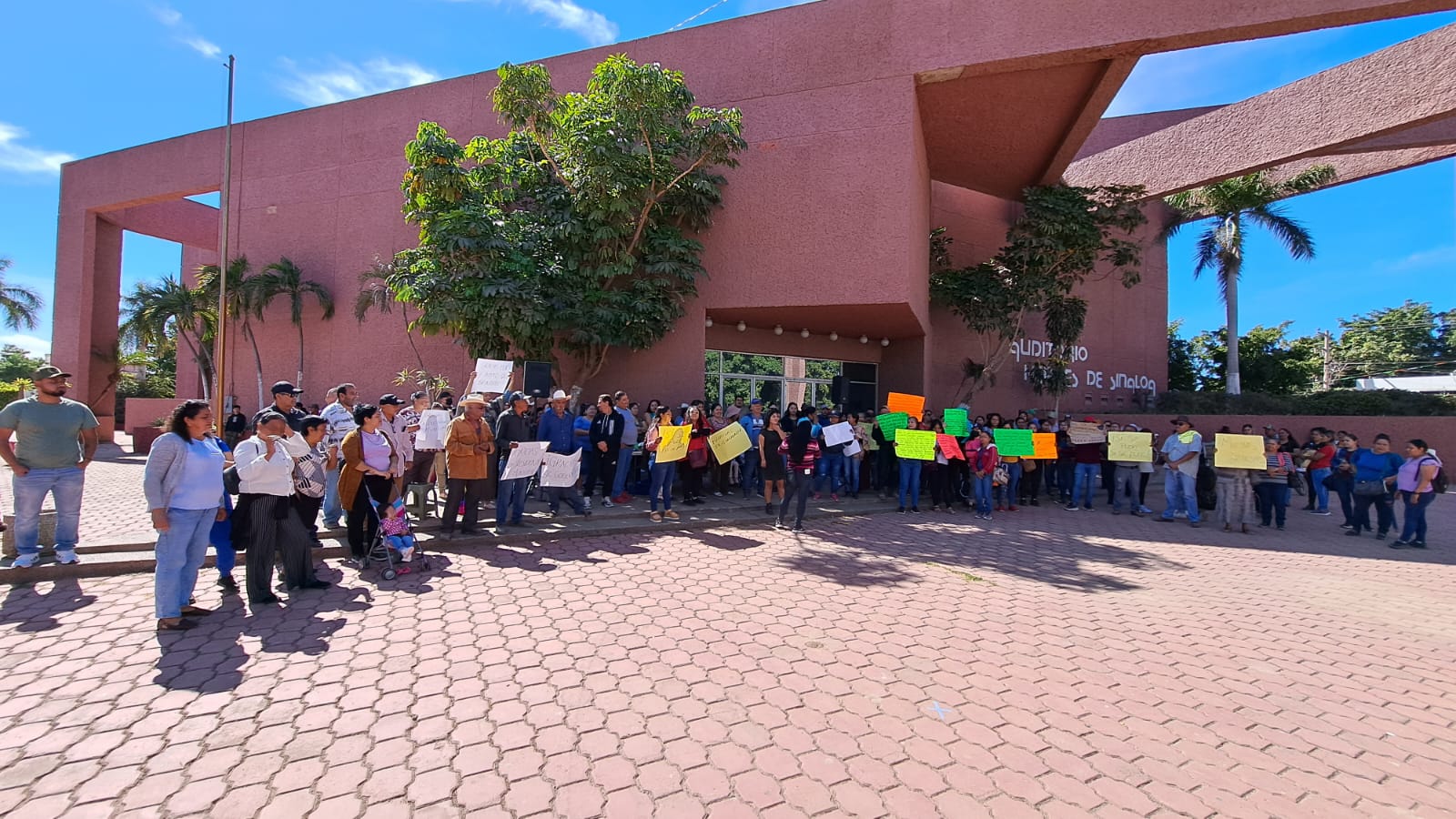 Integrantes de la Coordinadora Estatal para la Defensa del Derecho Humano a la Vivienda y Reservas Territoriales afuera de las instalaciones del Palacio Municipal en Guasave con pancartas de agradecimiento