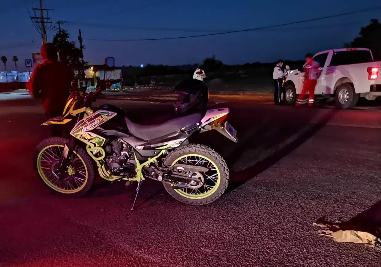 Motocicleta en la que viajaba la pareja. Al fondo se ve la camioneta que les chocó