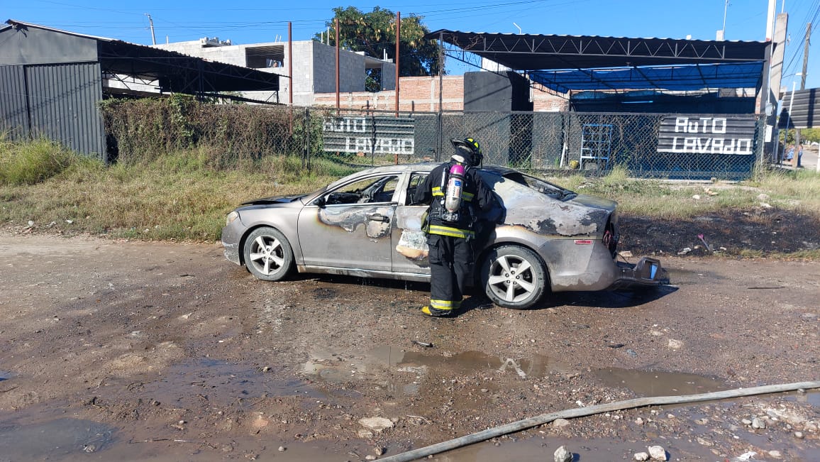 Bomberos combatiendo el incendio del vehículo hasta sofocar por completo las llamas.