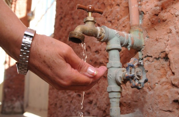Una mano de mujer cayéndole agua de la llave