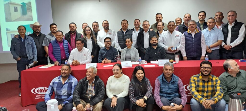 Alcalde de Culiacán en medio de socios de la CMIC posando para una fotografía