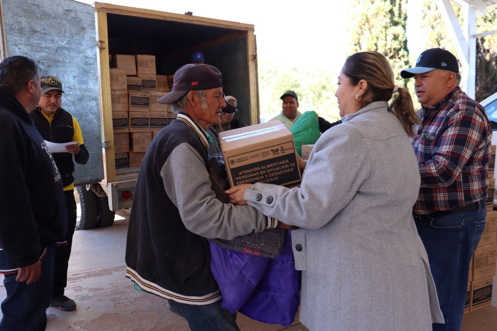 Personas con cobijas y apoyos alimenticios que les dio el gobierno en la sierra de Sinaloa Municipio