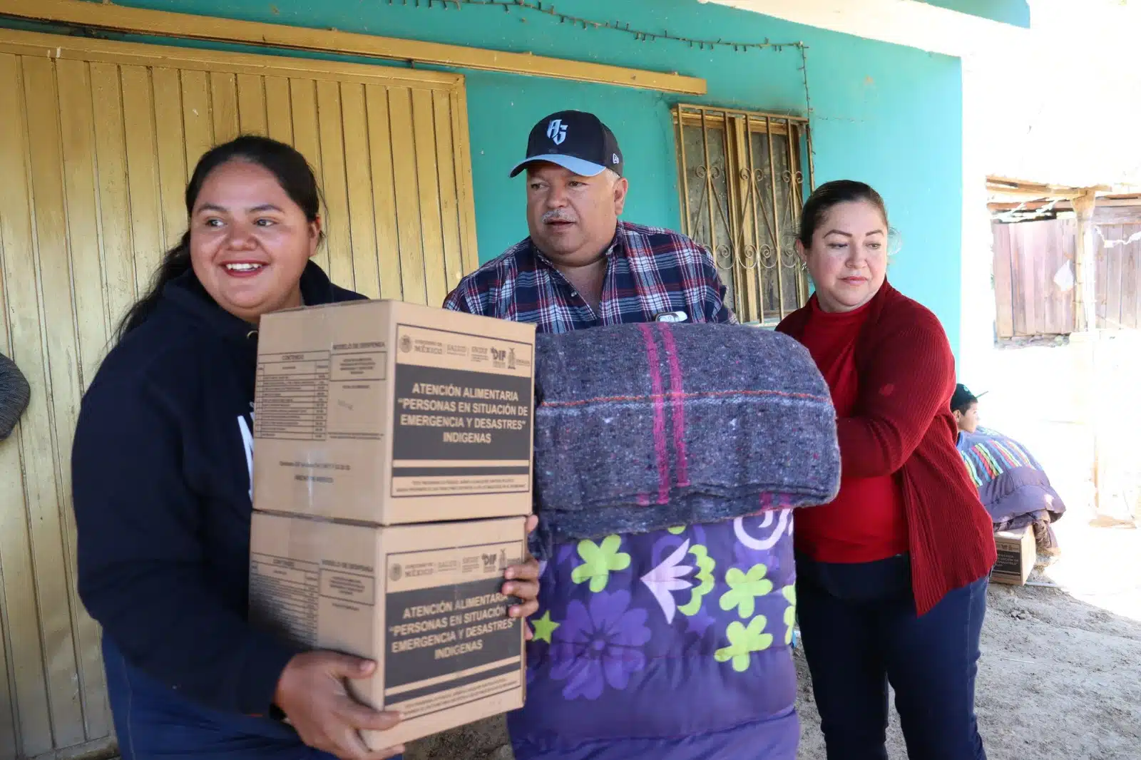 Personas con cobijas y apoyos alimenticios que les dio el gobierno en la sierra de Sinaloa Municipio