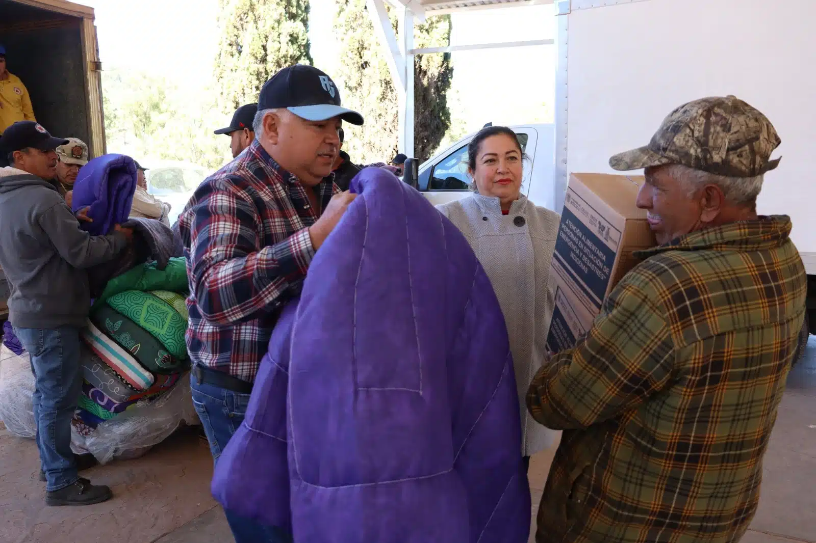 Personas con cobijas y apoyos alimenticios que les dio el gobierno en la sierra de Sinaloa Municipio