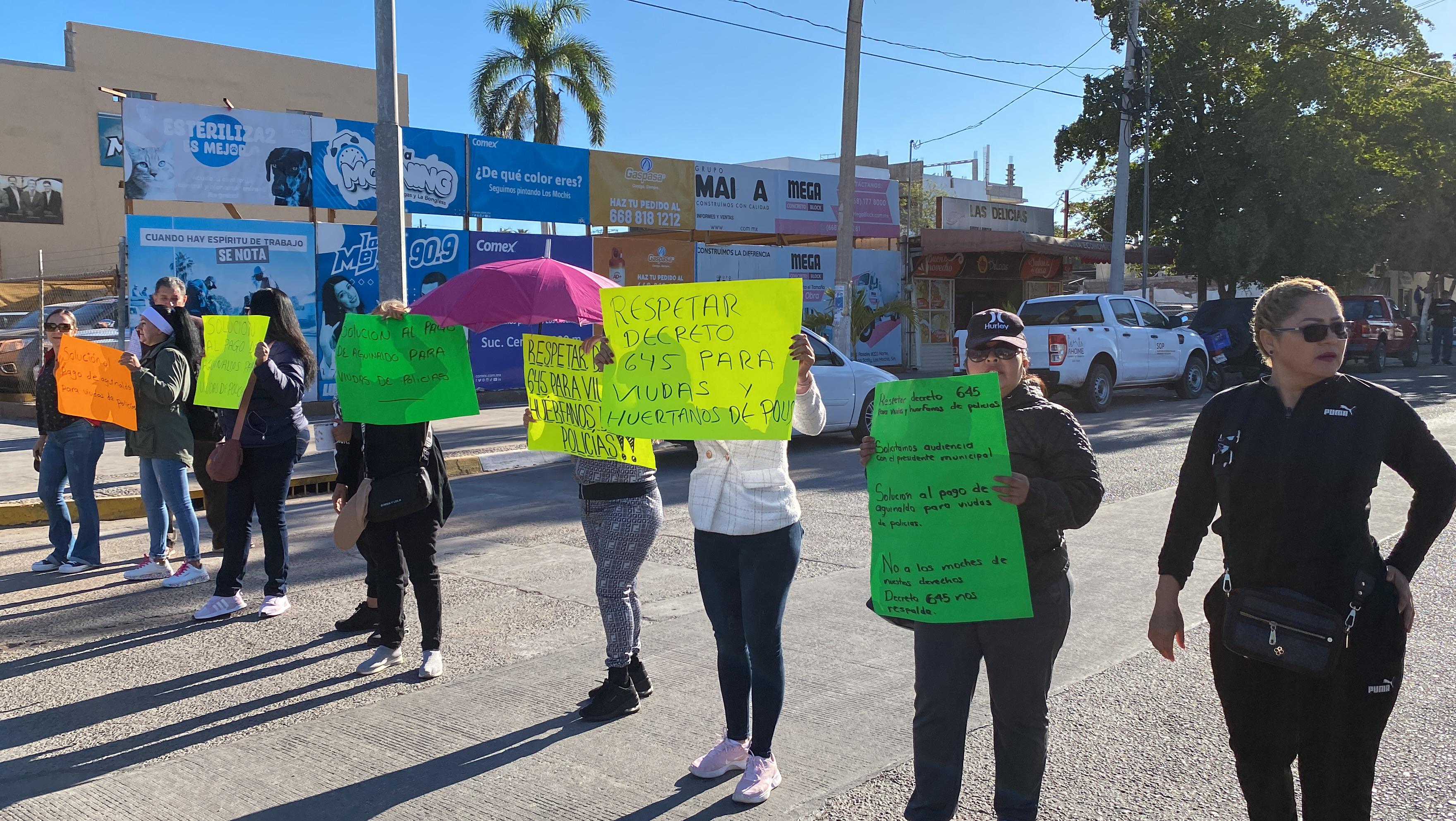 Personas con pancartas en medio de una calle que tienen bloqueada