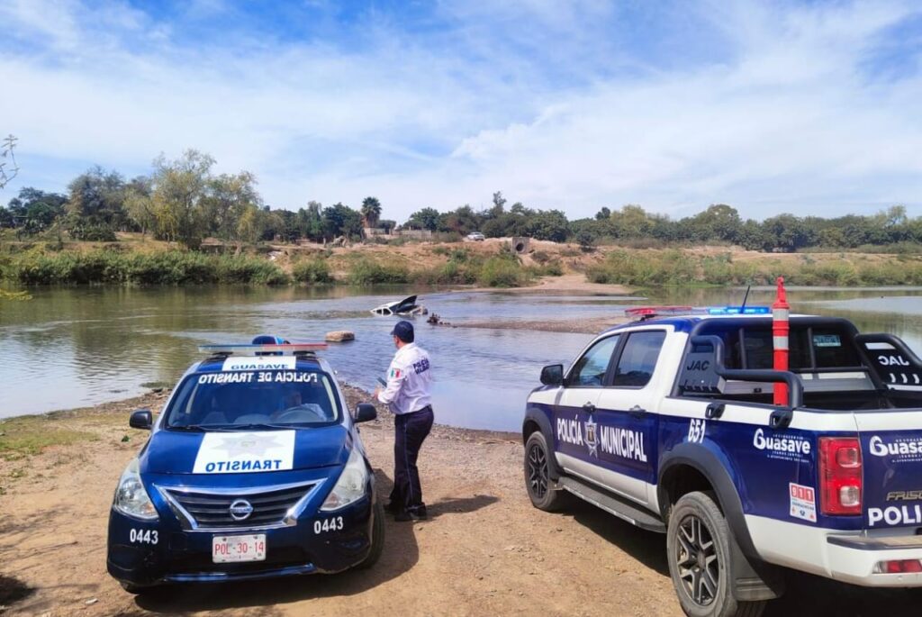 Elementos y carros de la Policía Municipal de Guasave y al fondo la camioneta en la que viajaba Fabiola cuando cayó al río Sinaloa