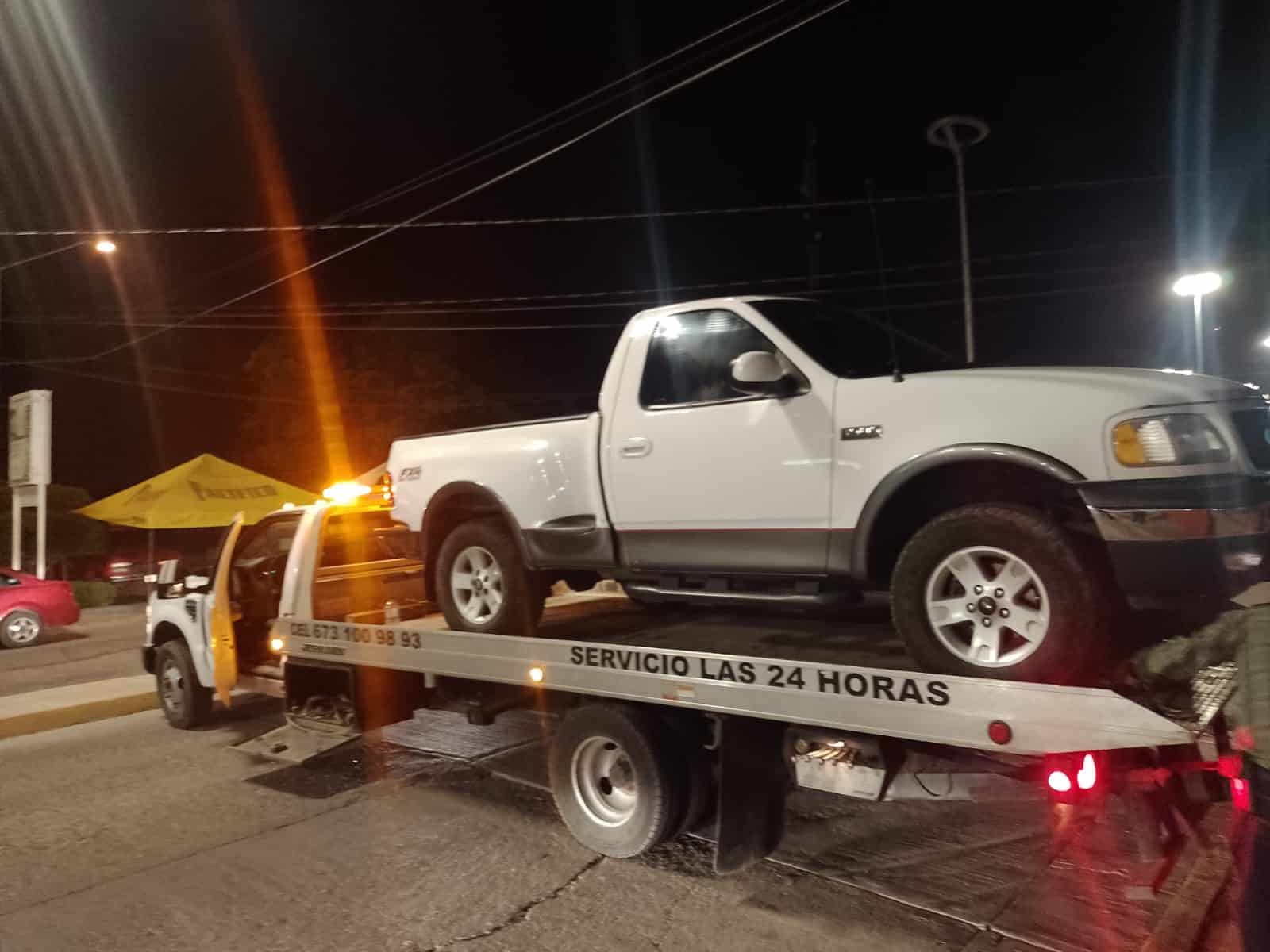 Camioneta Ford blanca sin placas arriba de una grúa en Guamúchil