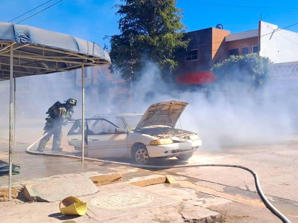 Elemento de bomberos apagando el incendio de un carro en Ahome