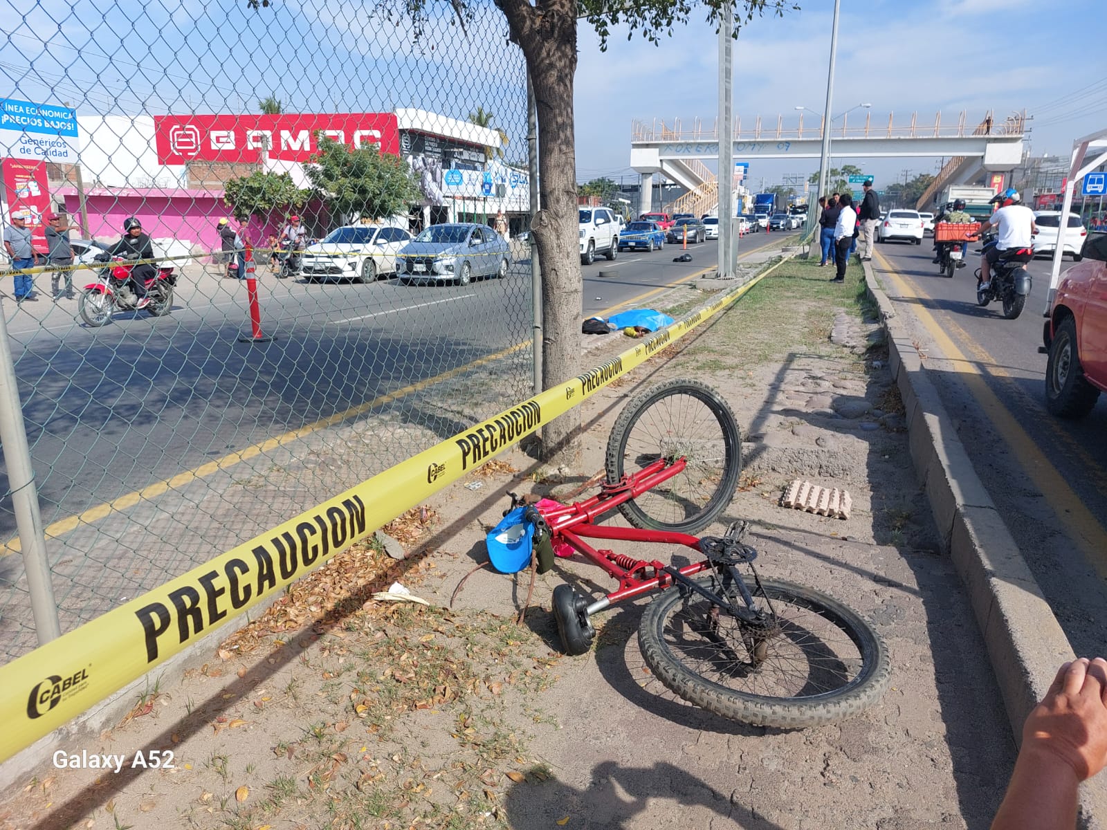 Bicicleta color rojo tirada sobre el camellón de una avenida en Mazatlán