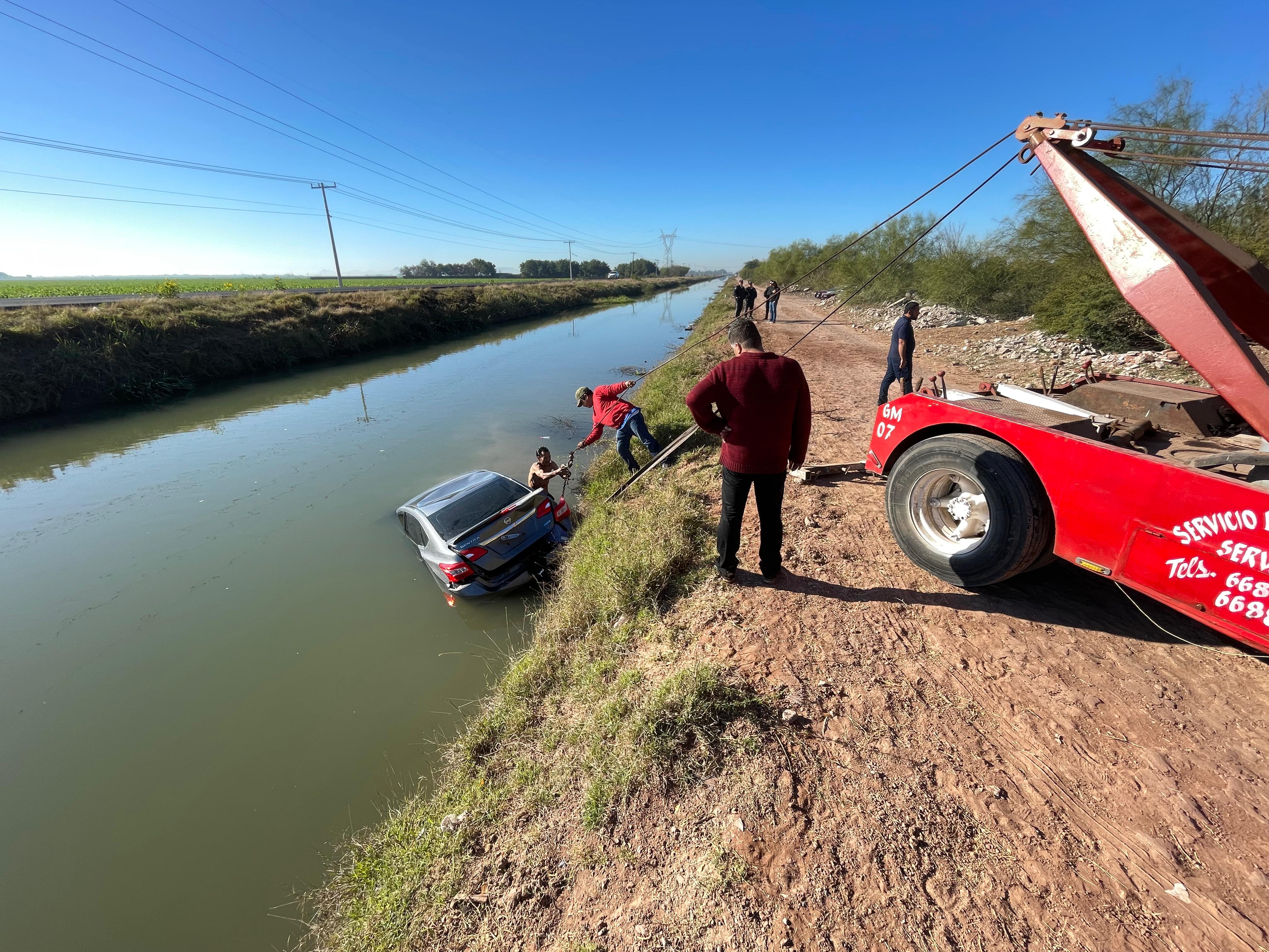 Grua rescata un auto Nissan Sentra de las aguas del canal Lateral 18 en Ahome