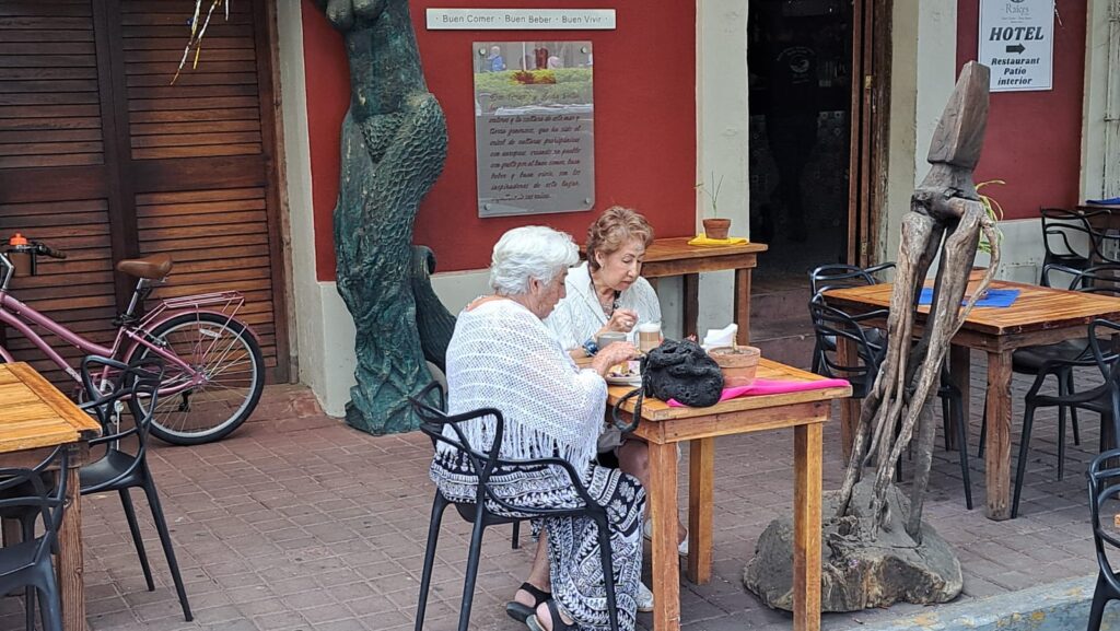 Rosa Gutiérrez y María Esperanza González sentadas afuera de uno de los restaurantes de la plazuela Machado.