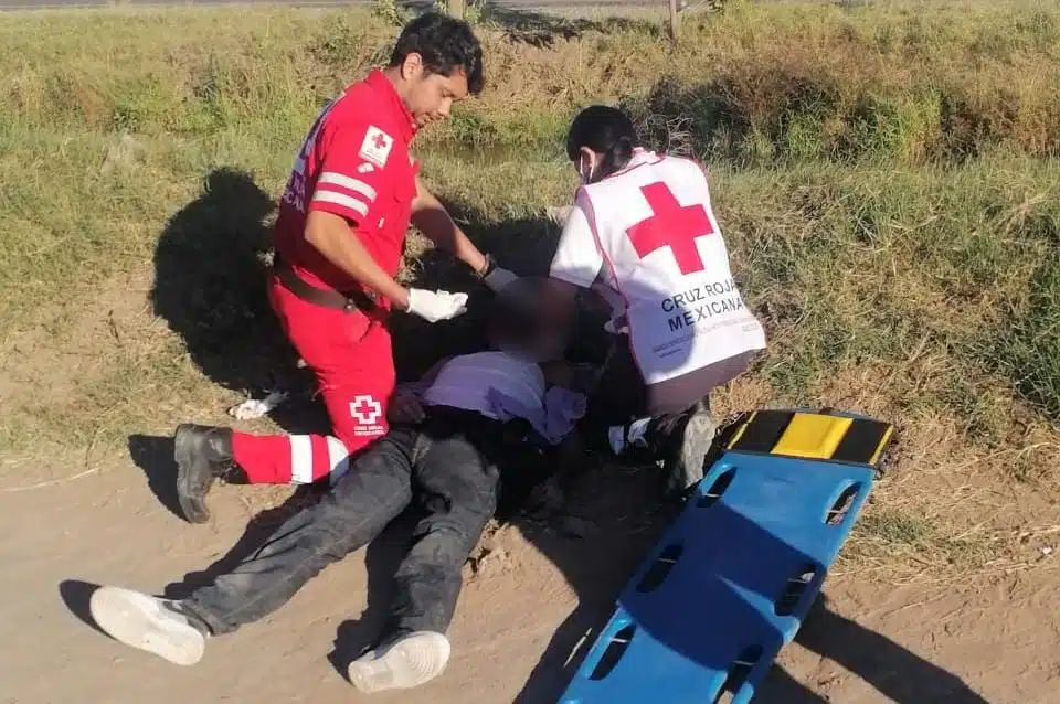 2 elementos de la Cruz Roja dando los primeros auxilios a Álvaro que tuvo un accidente en Guasave