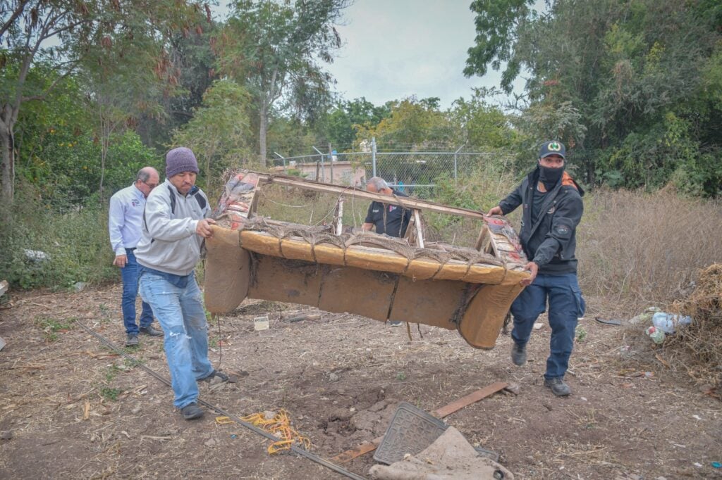 Trabajadores cargando un sofá en condiciones deplorables