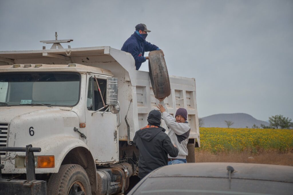 Trabajadores ayudando a subir un neumático al camión