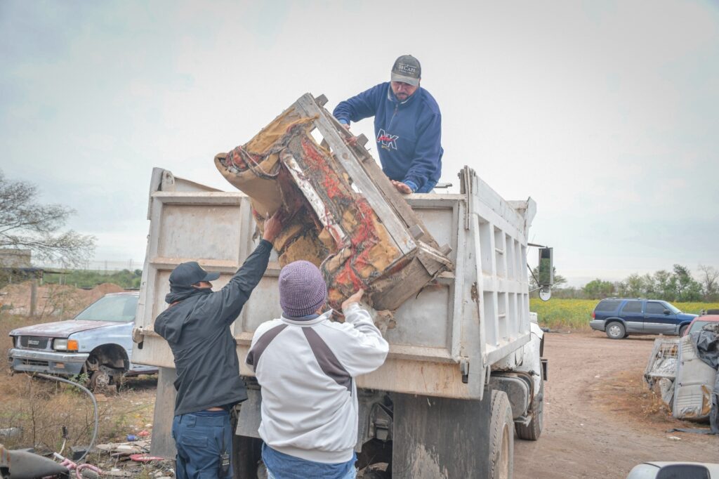 Trabajadores ayudando a subir un sofá viejo a un camión