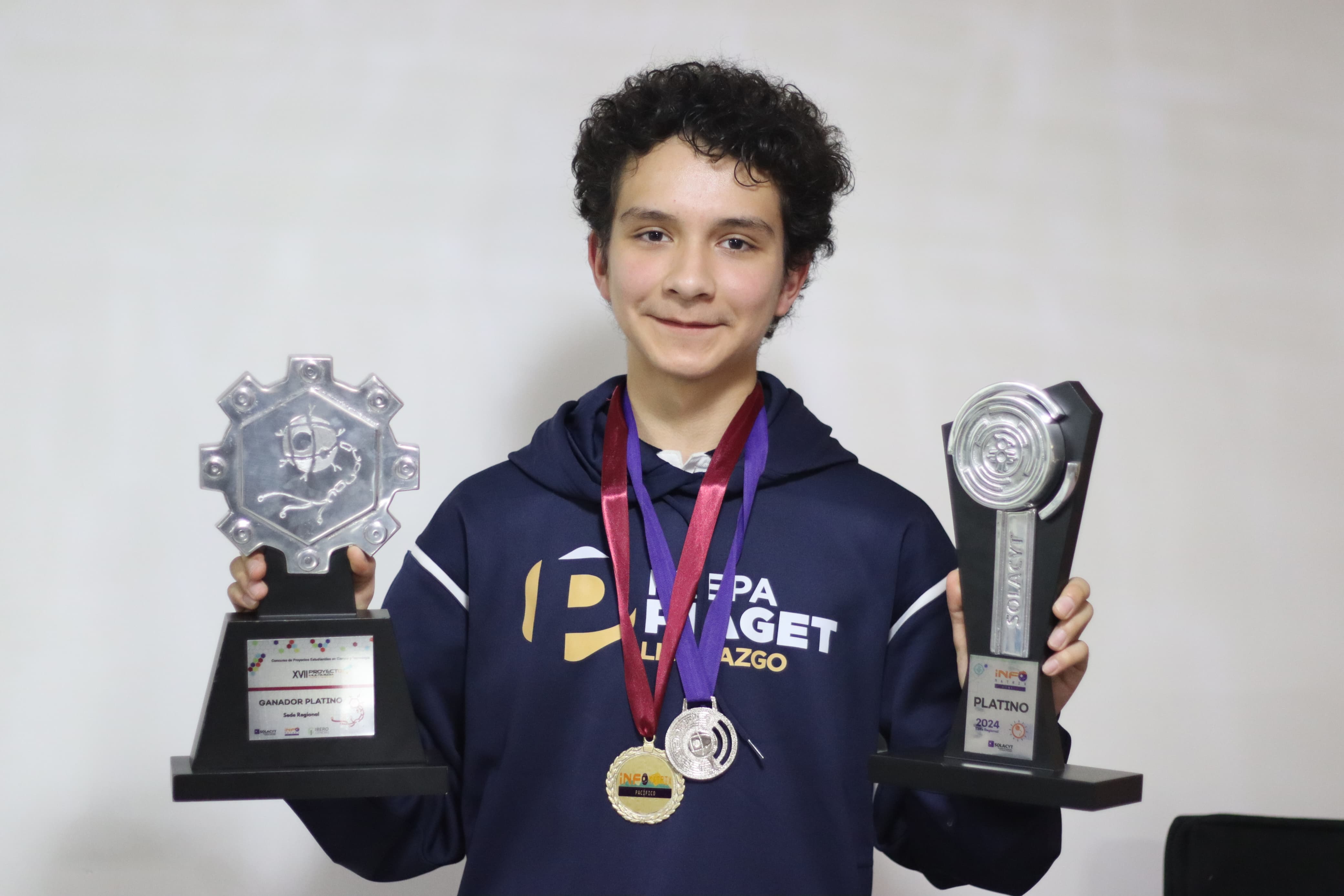 Joel Joab Grijalva Morales con 2 premios en sus manos y 2 medallas