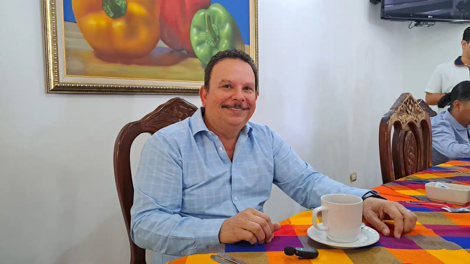 José Alfredo López Castro sentado frente a un comedor con una tasa de café