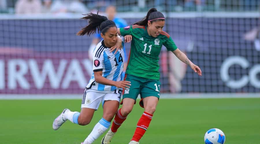 2 jugadoras de futbol, una del equipo de la Selección de México y la otra de Argentina, disputándose un balón en la Copa Oro Femenil 2024