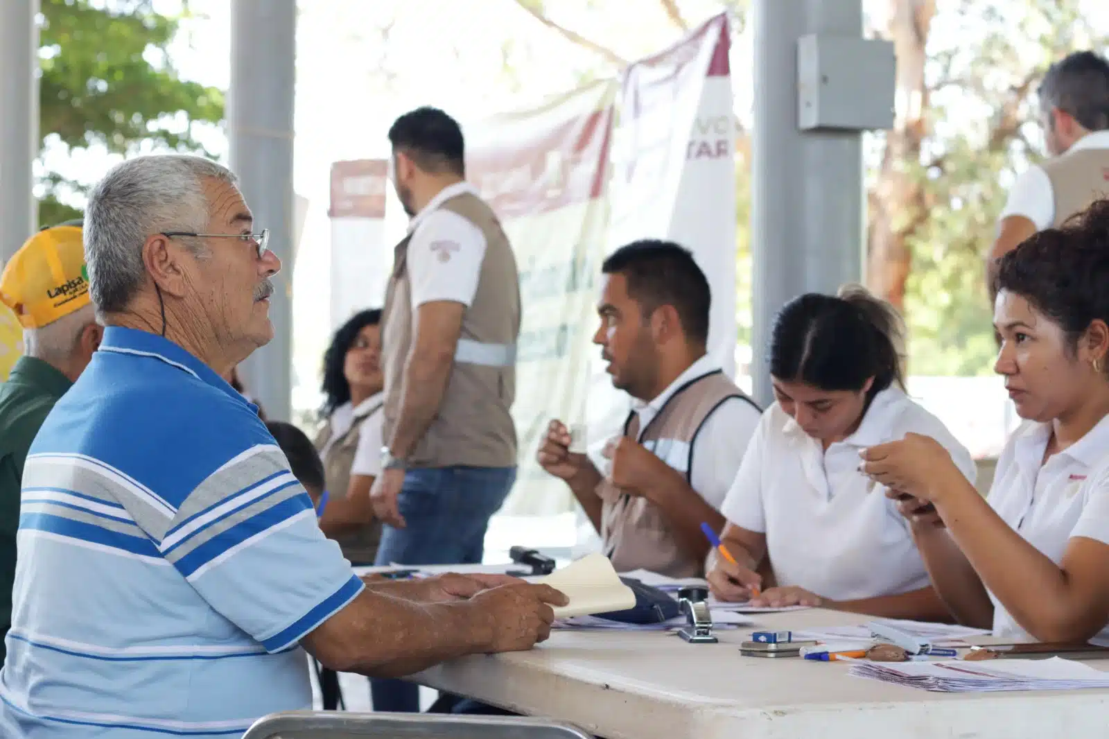 Trabajadores del Bienestar entregando la tarjeta de la pensión a adultos mayores en Ahome