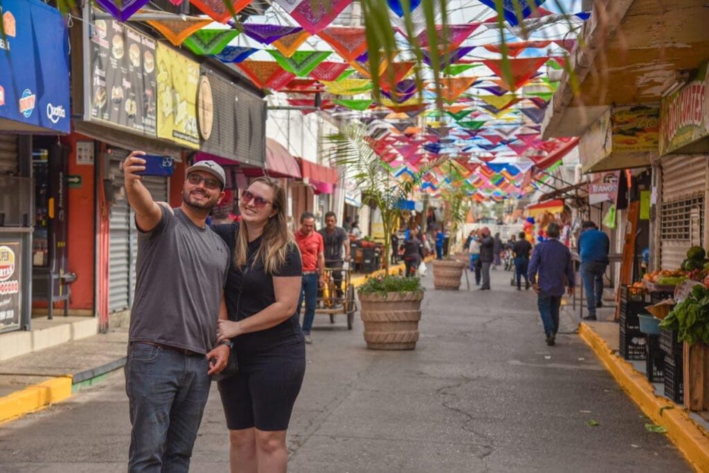 Personas tomándose fotografías con la decoración de fondo en el callejón Agustín Melgar en Los Mochis.