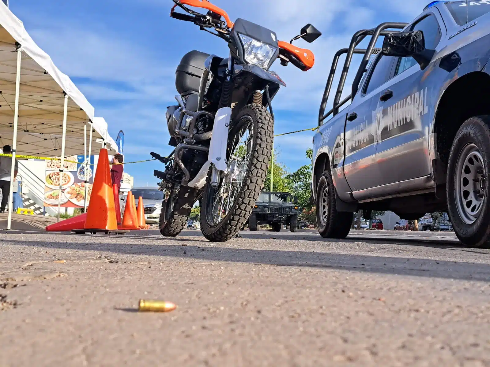 Patrulla de la Policía Municipal de Culiacán, una motocicleta y cinta amarilla delimitando el área del restaurante donde murió Abel