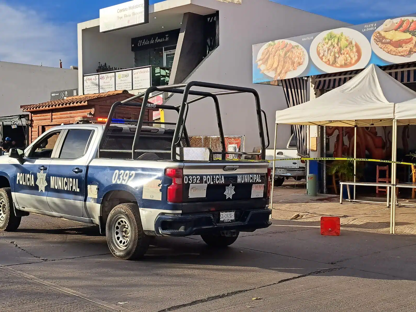 Patrulla de la Policía Municipal de Culiacán y cinta amarilla delimitando el área del restaurante donde murió Abel