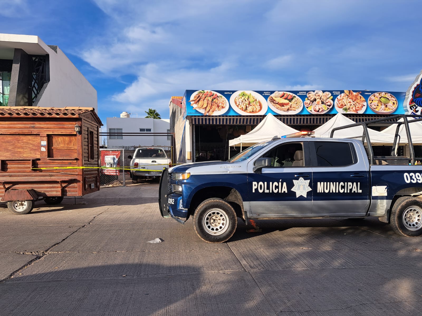 Patrulla de la Policía Municipal de Culiacán y cinta amarilla delimitando el área del restaurante donde murió Abel