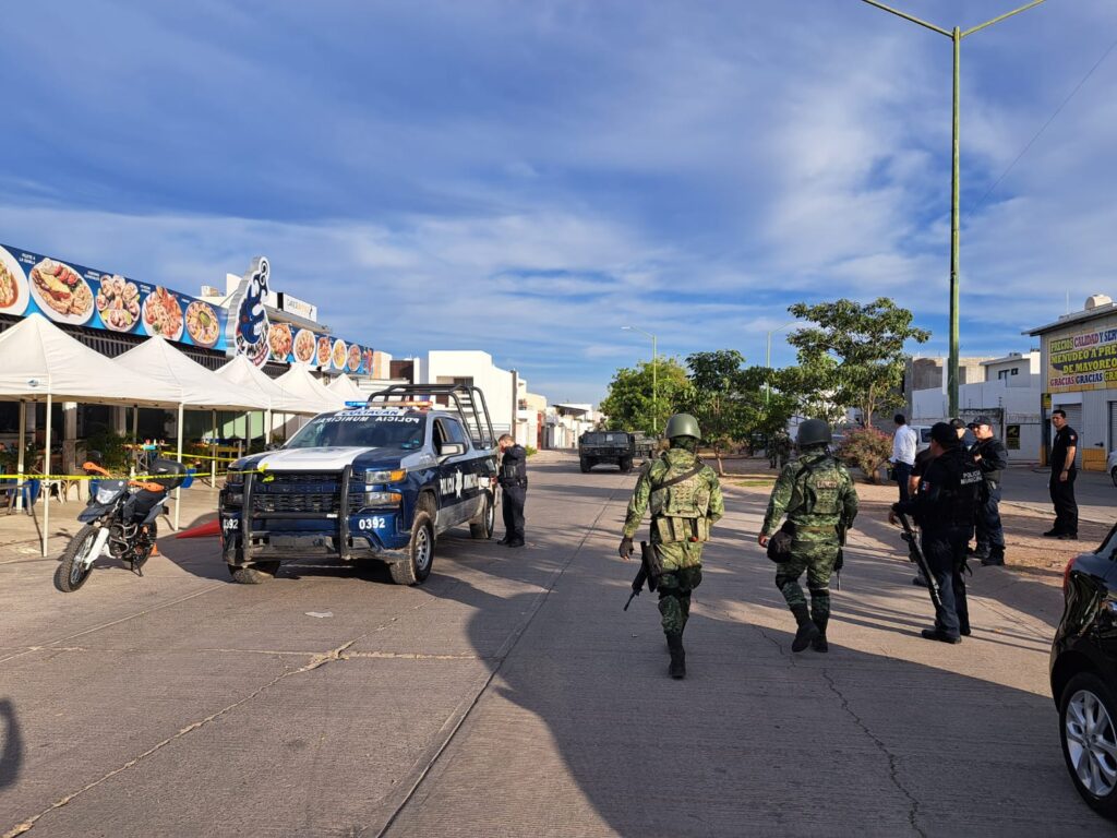 Patrulla de la Policía Municipal de Culiacán, una motocicleta, Ejército Mexicano y cinta amarilla delimitando el área del restaurante donde murió Abel