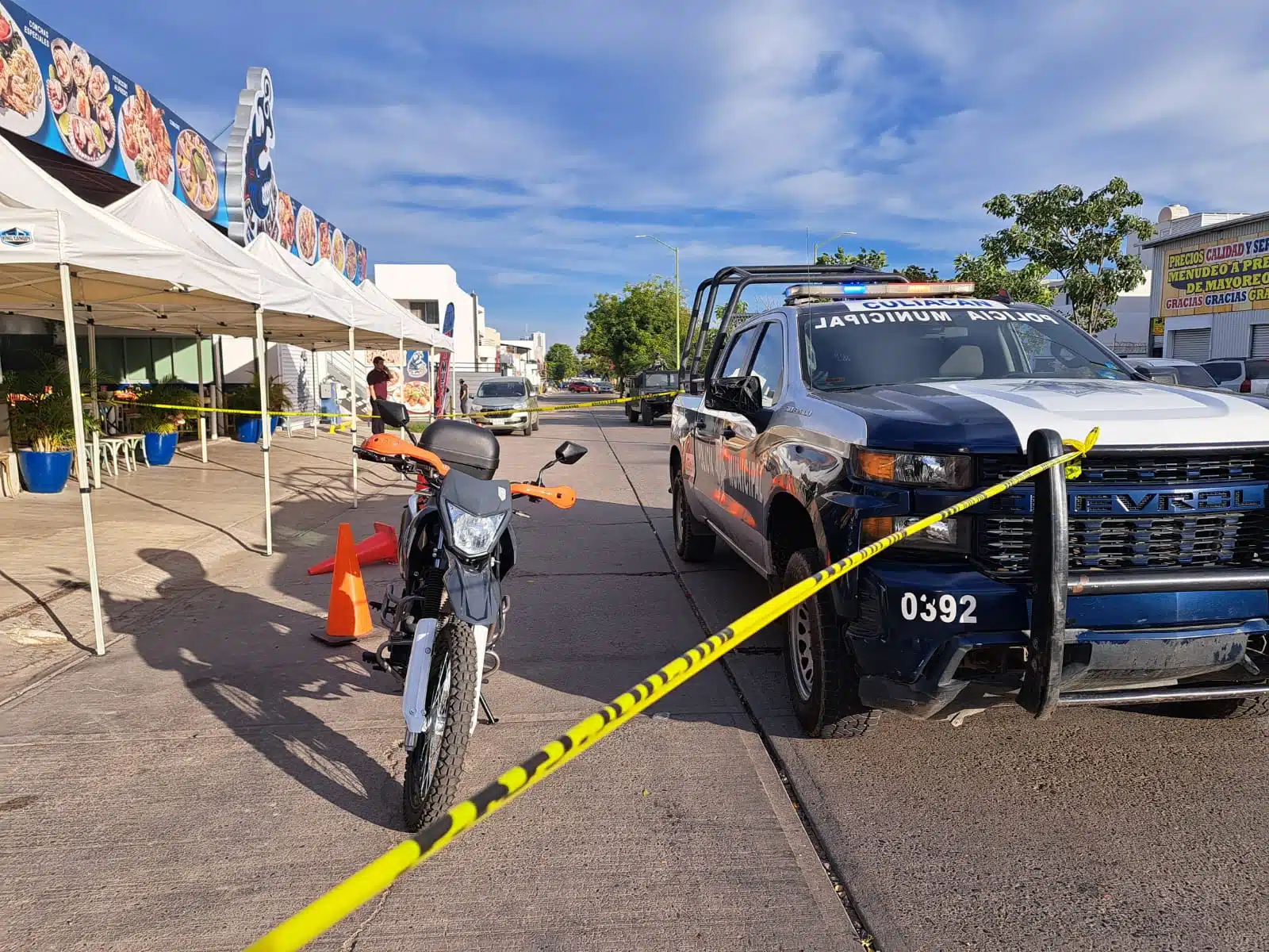Patrulla de la Policía Municipal de Culiacán, una motocicleta y cinta amarilla delimitando el área del restaurante donde murió Abel