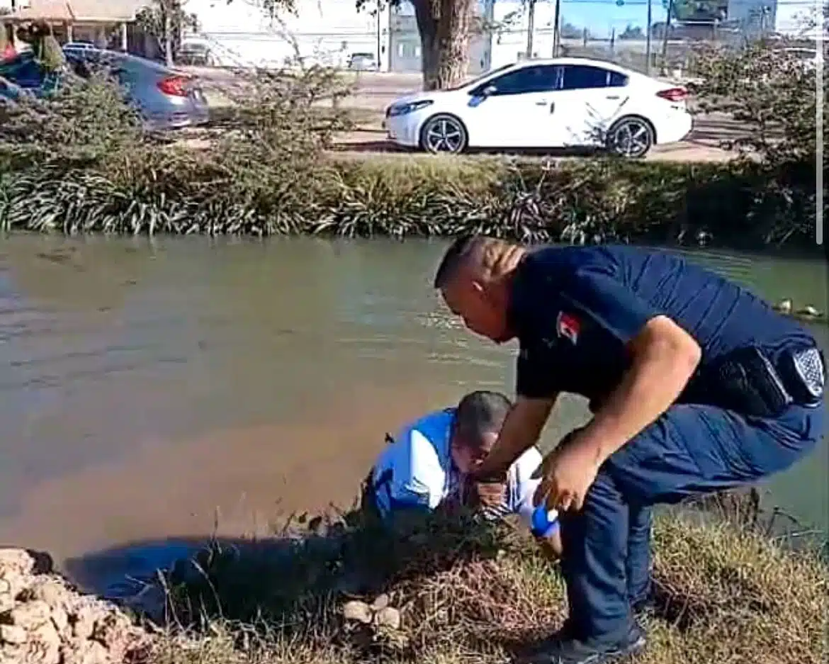 Elemento de la policía municipal de Ahome sacando a una persona del agua