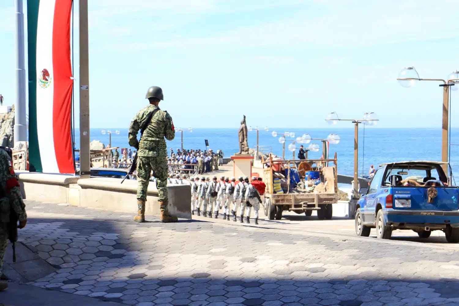 Soldado frente a la bandera de México en playa de Mazatlán