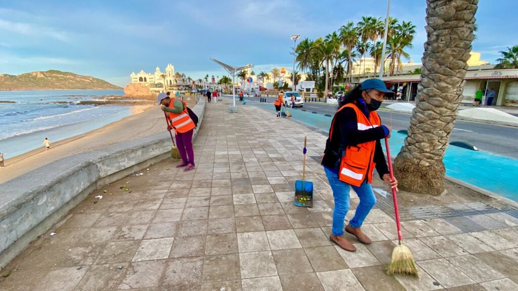 Trabajadoras de Aseo Urbano mientras barren el malecón de Mazatlán