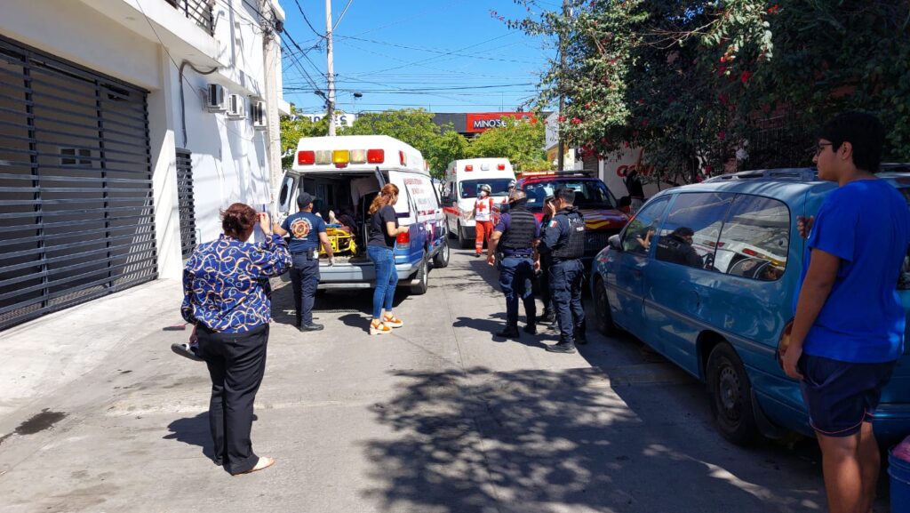 Vecinos de la mujer electrocutada, policías y paramédicos afuera de la casa en Mazatlán