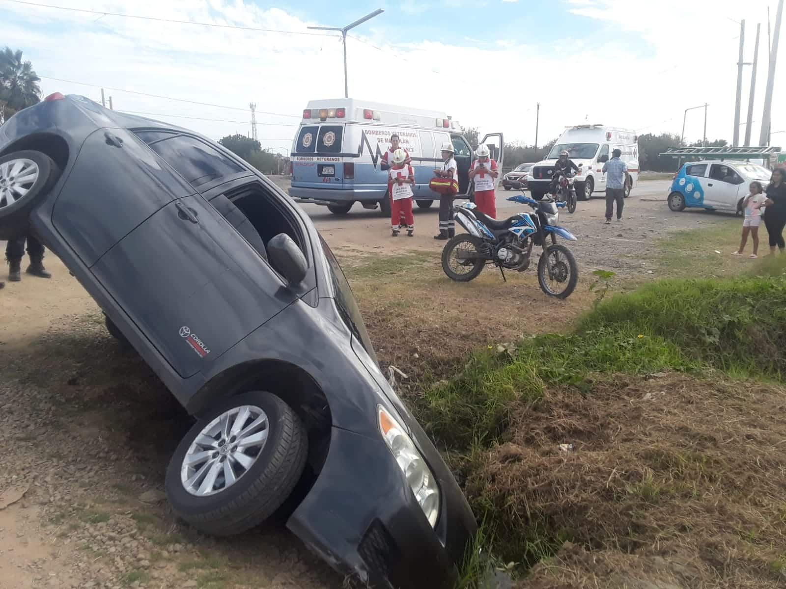 Automóvil inclinado hacia un costado tras caer en el pozo