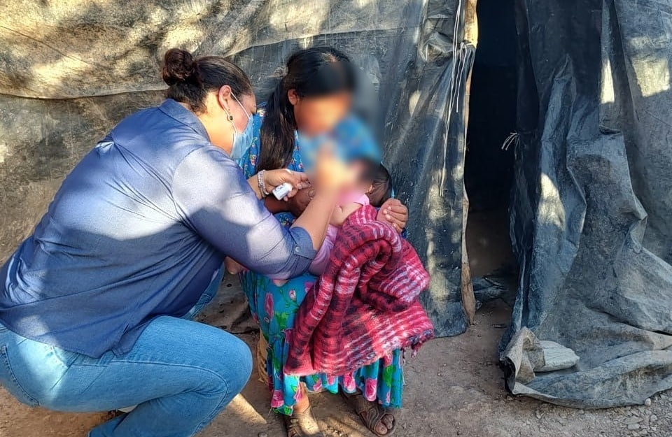 Mujer atendiendo a niño hijo de jornaleros agrícolas