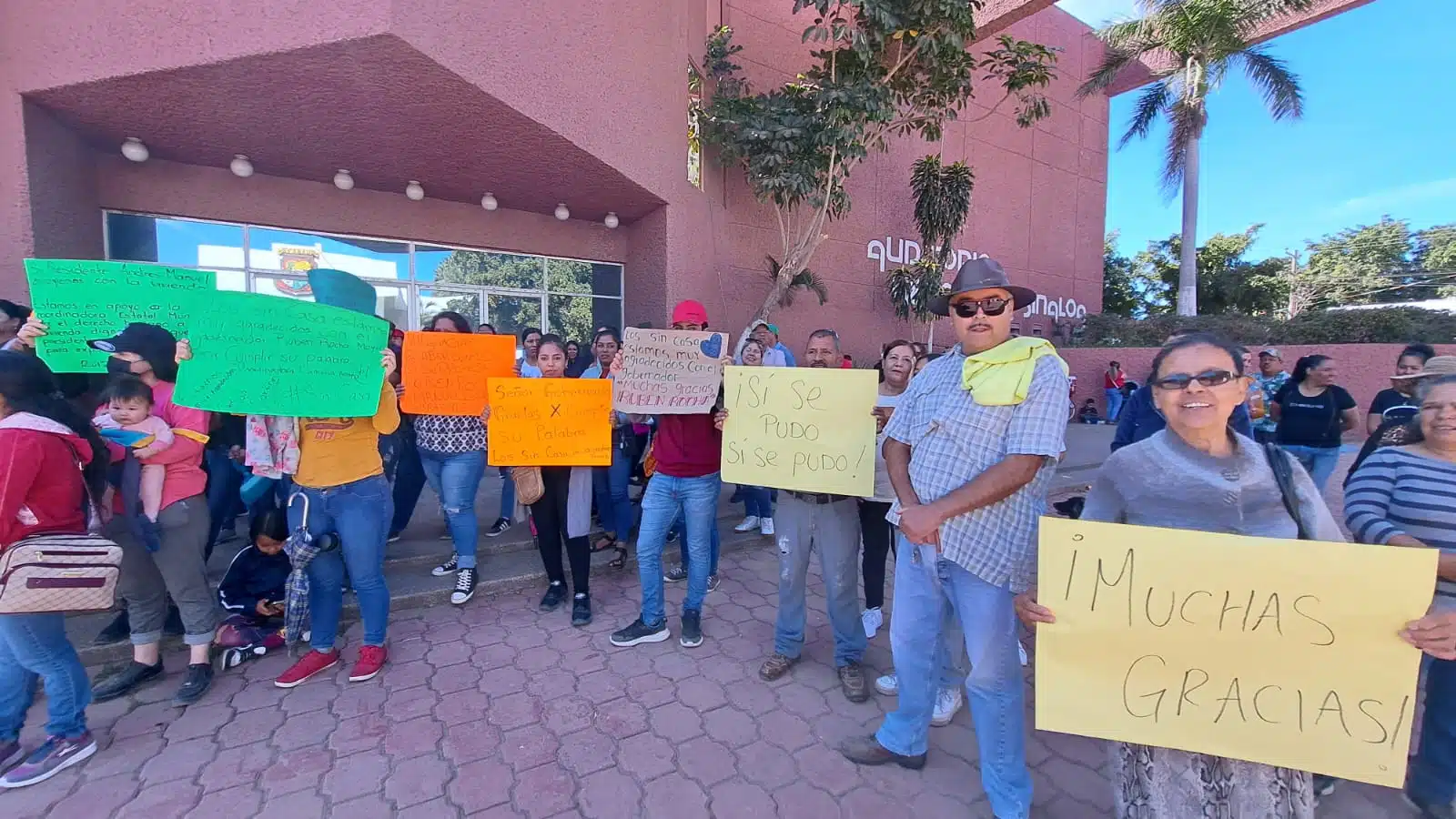 Integrantes de la Coordinadora Estatal para la Defensa del Derecho Humano a la Vivienda y Reservas Territoriales afuera de las instalaciones del Palacio Municipal en Guasave con pancartas de agradecimiento