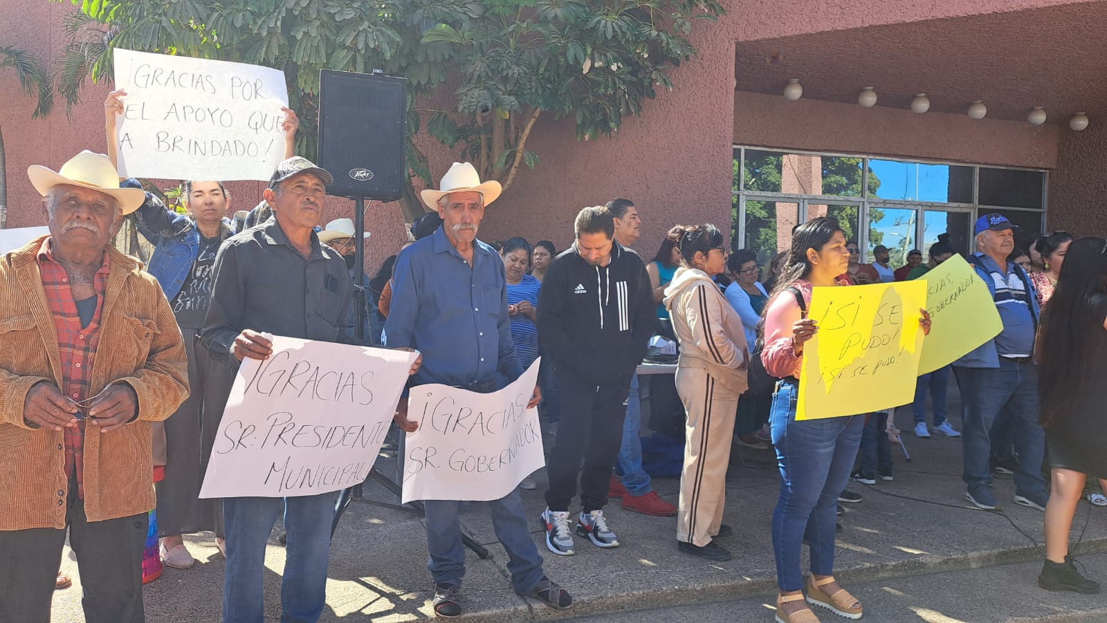 Integrantes de la Coordinadora Estatal para la Defensa del Derecho Humano a la Vivienda y Reservas Territoriales afuera de las instalaciones del Palacio Municipal en Guasave con pancartas de agradecimiento