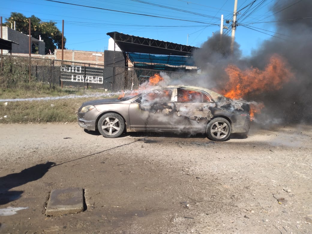 Bomberos combatiendo el incendio del vehículo hasta sofocar por completo las llamas.