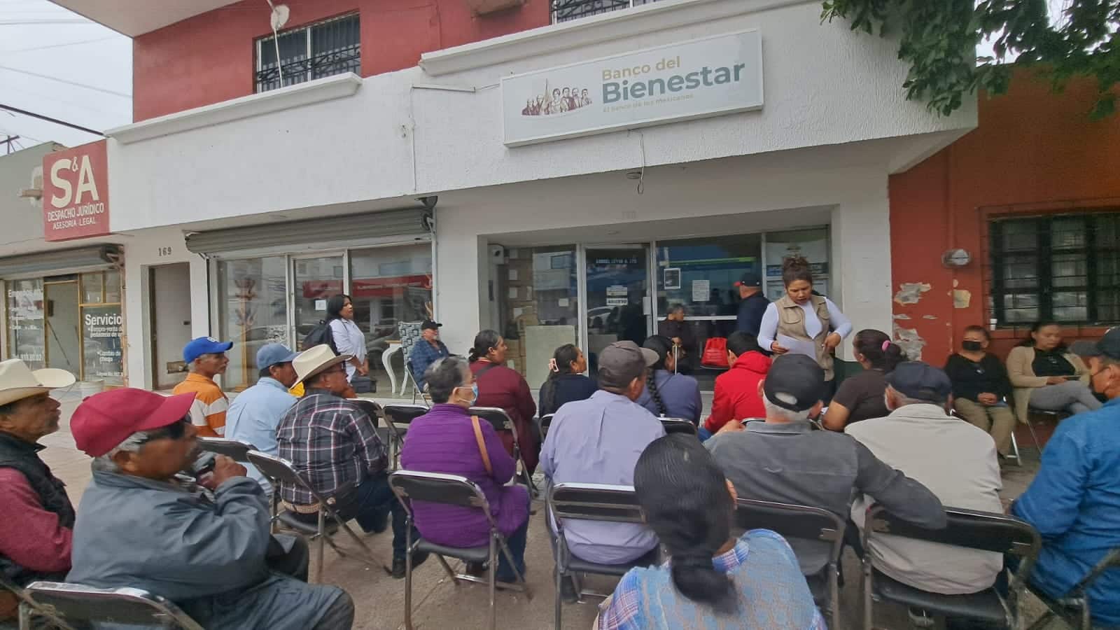 Personas acudiendo a las oficinas de Bienestar para recoger sus tarjetas