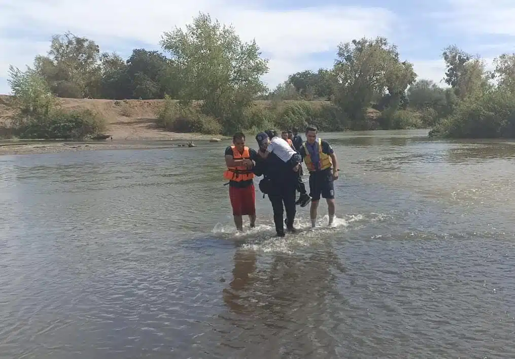 Policías rescatando a familia que cayó al río Sinaloa en Guasave.