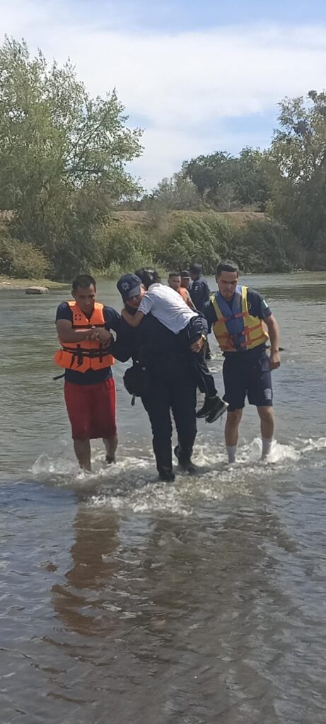 Policías rescatando a familia que cayó al río Sinaloa en Guasave.