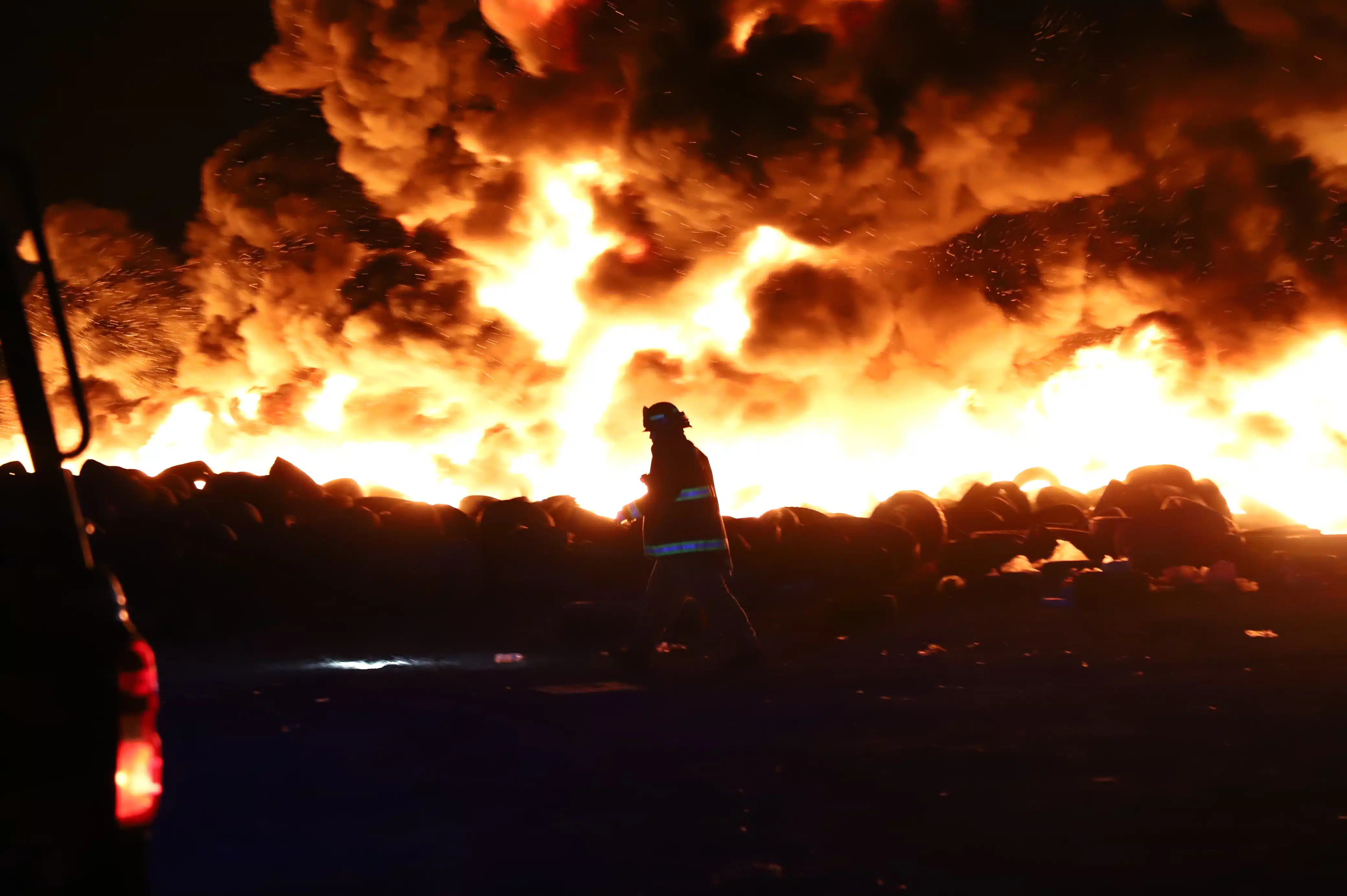 Bombero enfrentándose a las llamas en el basurón municipal