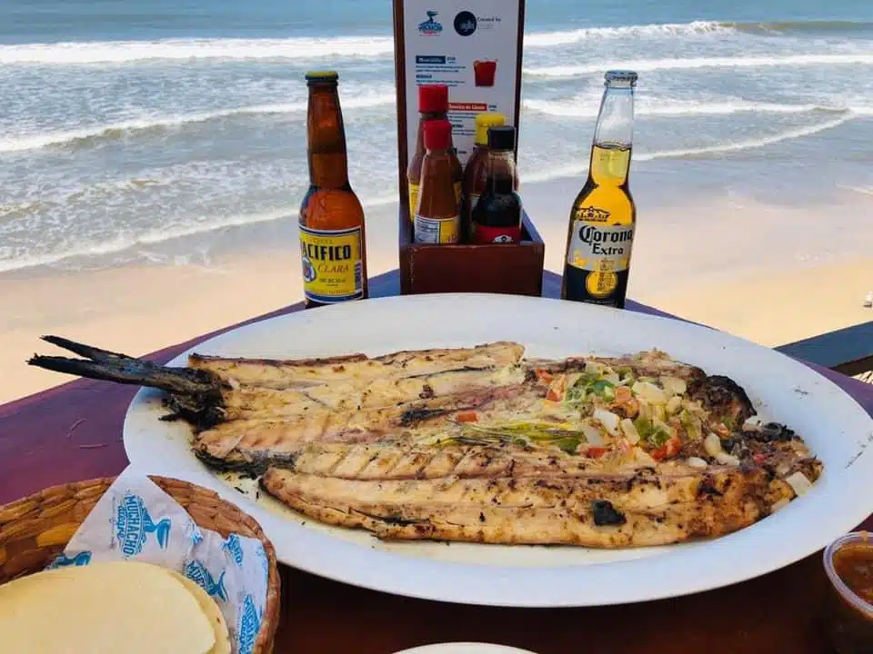 Pescado a las brasas acompañados de cerveza fría