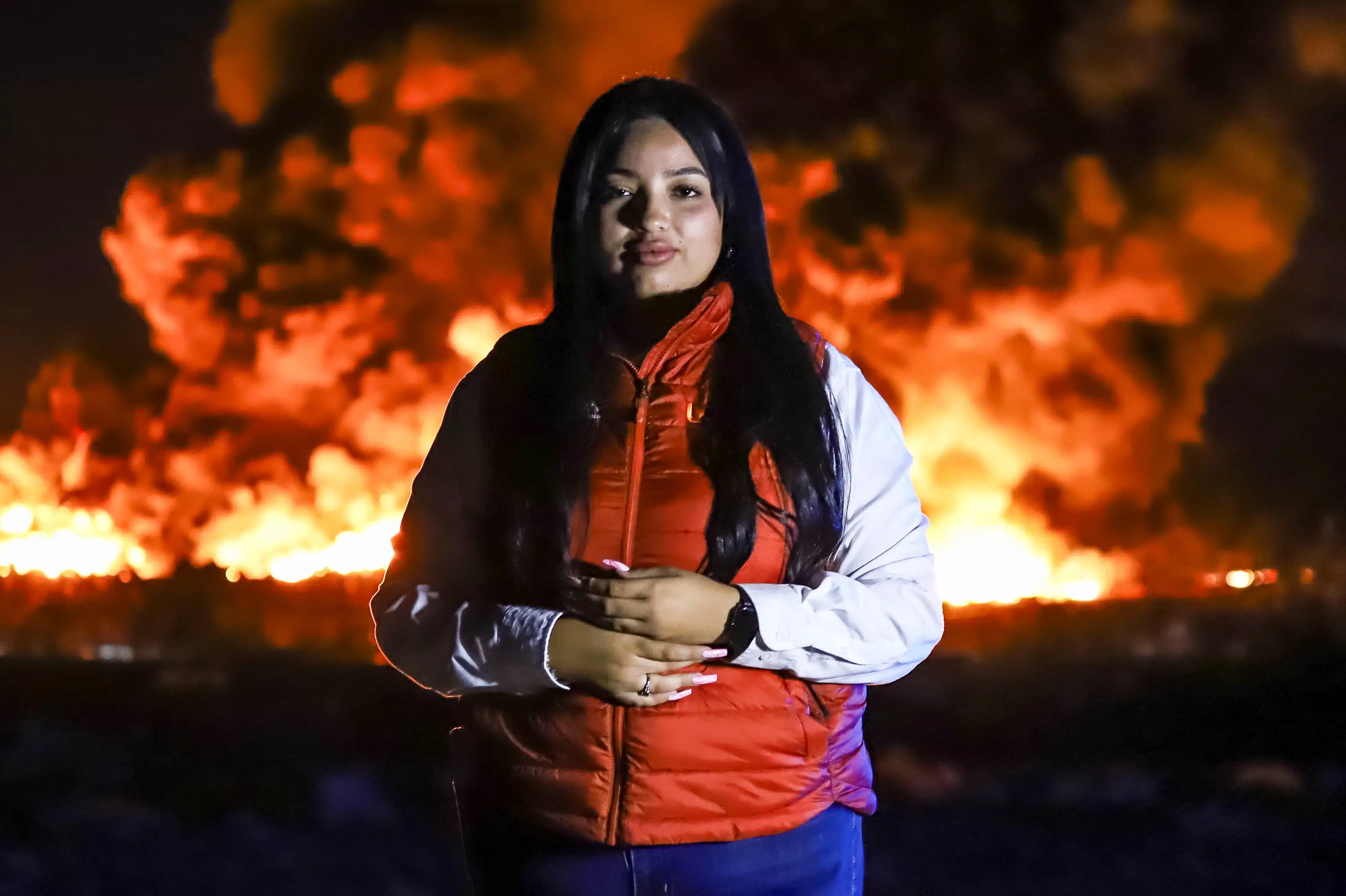 Tere Navia, reportera policiaca de Línea Directa, cubriendo la quema del basurón de Culiacán la madrugada del 7 de marzo