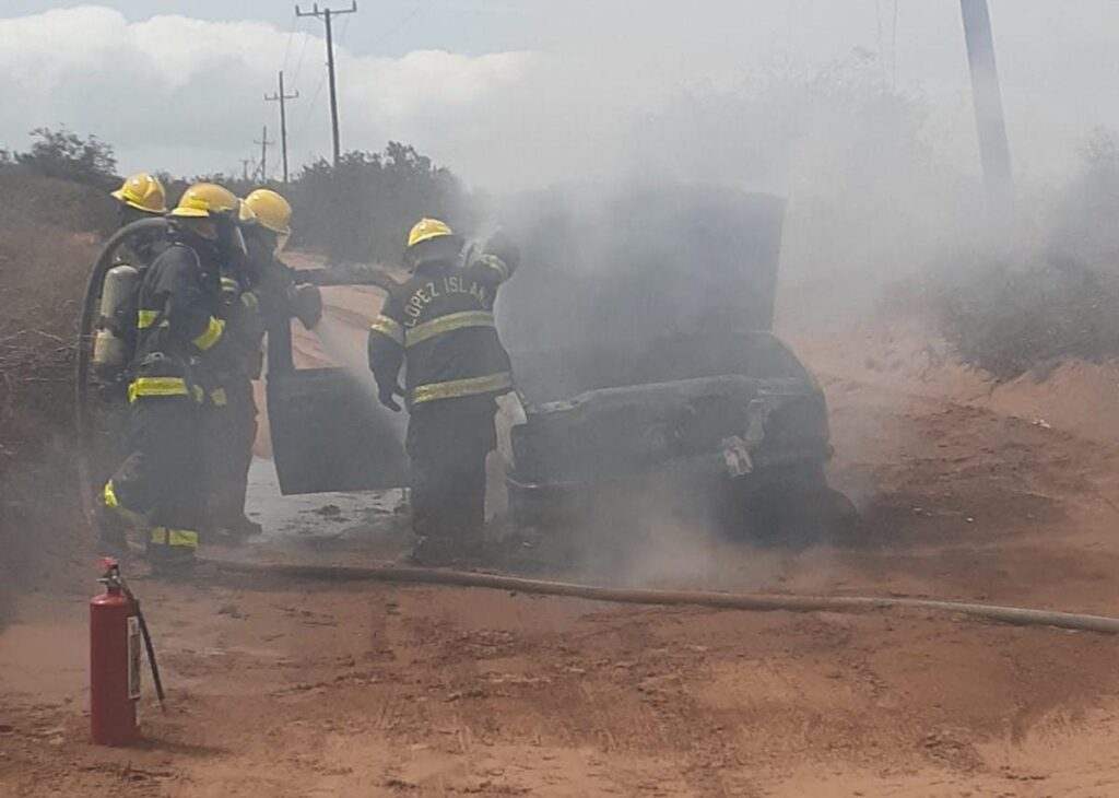 Bomberos sofocando el incendio del vehículo