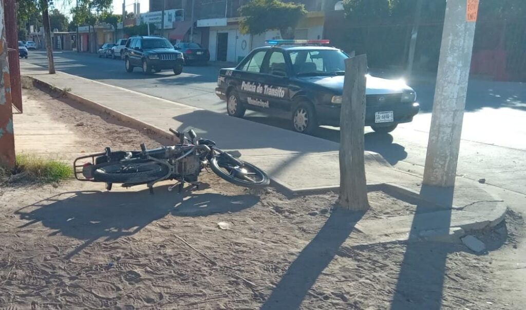 Motocicleta tirada junto a un vehículo de la Policía de Tránsito