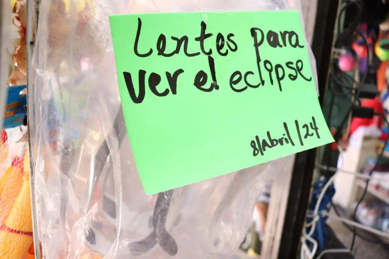 Cartelón de venta de lentes especiales para ver el eclipse